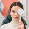 a woman covering her eyes for eye checkup